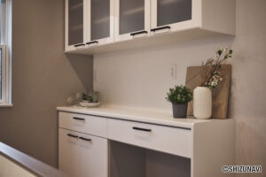 【A棟】高機能で高級感のあるホワイトカラーのキッチン収納。広々とした収納スペースは、調理器具や食器、食品の収納に最適。また、棚板の高さを調整できるため、アイテムに合わせてカスタマイズができます。