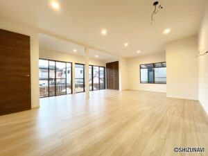 【リフォーム済/リビング】南面の一面が窓となっているリビングスペースです。キッチンと2室を併合し、24帖のリビングとなりました。フローリング上張りとクロス張替、建具交換を行いました。
