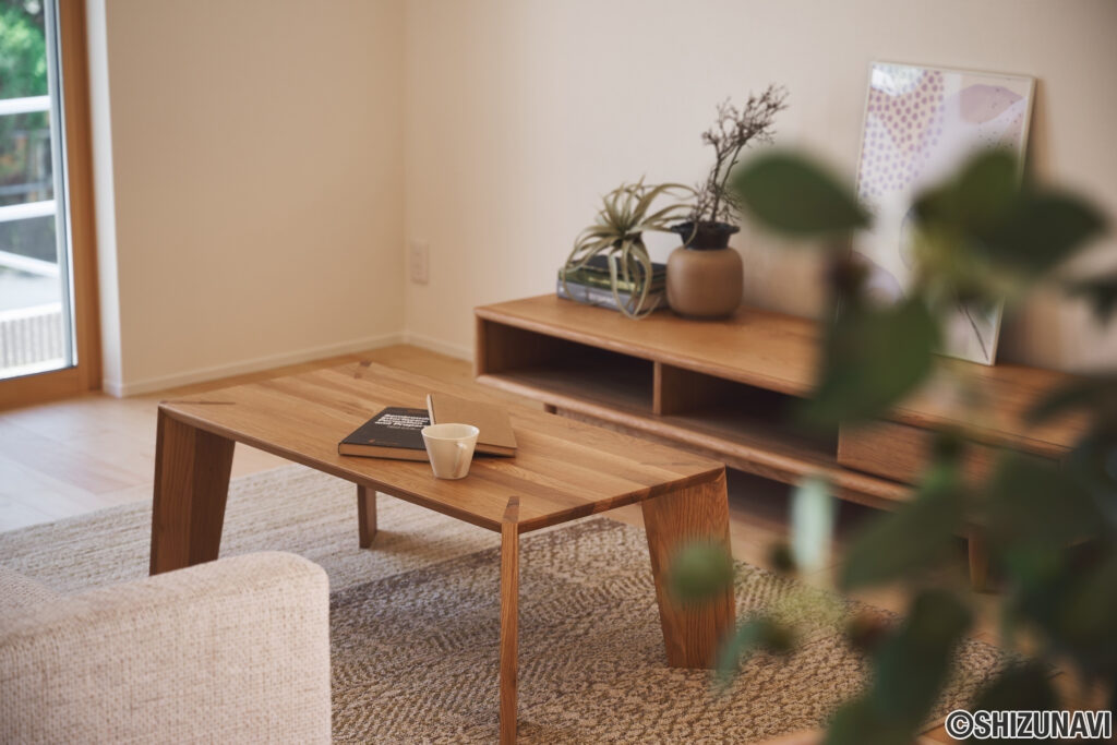 木製のローテーブルとTVボード、ざっくりした質感のラグ、観葉植物などをコーディネート。ナチュラルな素材に囲まれることで、視覚的な安心感と落ち着きが生まれます。