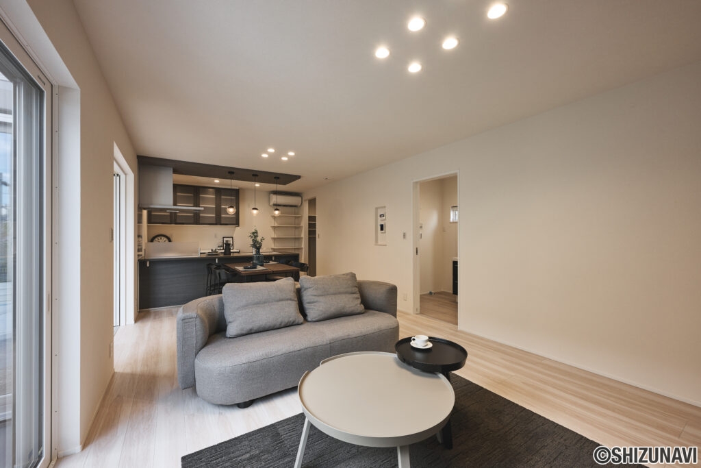 落ち着いたトーンの空間に存在感を放つのは、丸みのあるフォルムが印象的なソファー。やわらかなグレージュの生地がリビング全体を包み込み、上品で心地よいくつろぎを演出します。