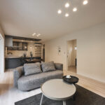 落ち着いたトーンの空間に存在感を放つのは、丸みのあるフォルムが印象的なソファー。やわらかなグレージュの生地がリビング全体を包み込み、上品で心地よいくつろぎを演出します。