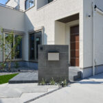 玄関まわりやアプローチにもデザイン性を追求し、住まい全体の印象をより一層引き立てています。落ち着いたトーンのタイルに映える植栽のグリーンが、訪れる人をやさしく迎えてくれます。機能性と美しさの両方を兼ね備えた、バランスのとれた洗練の一邸。