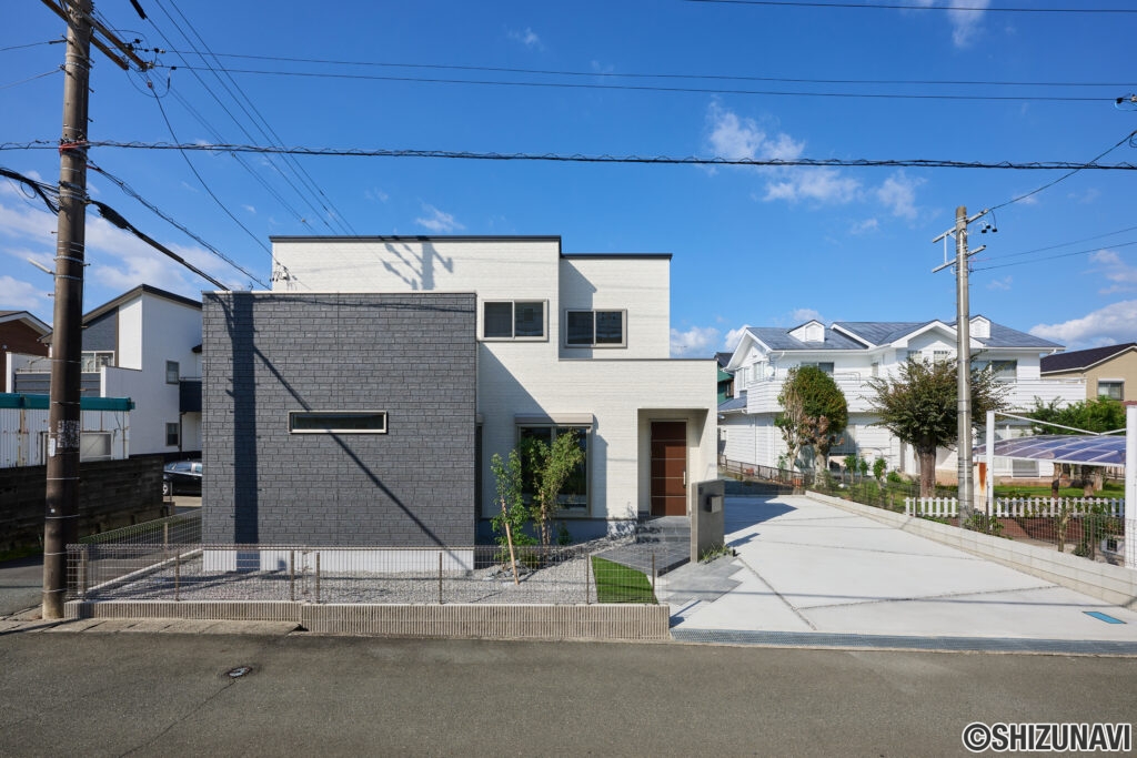 白とダークグレーのサイディングを組み合わせた、スタイリッシュで印象的な外観デザイン。南道路に面しており、日当たりの良さと開放感を感じられます。直線的なフォルムと異素材のコントラストが美しく、モダンな佇まいの中に上質な落ち着きを演出。