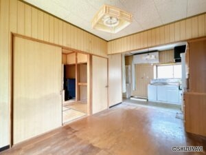 【リフォーム前/LDK別角度】隣に6帖の洋間があり、扉を外せば広いリビングとしてお使いいただけます。フローリング上張り、クロスの張替え、照明交換を行う予定です。