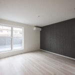 ご夫婦でゆったりと過ごせる、落ち着きのある洋室。南からの自然光が差し込む明るい空間に、ダークトーンのアクセントクロスが上質な雰囲気をプラスします。シンプルながらも洗練されたデザインで、家具の配置もしやすく、心地よい時間を過ごせる主寝室です。