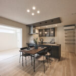 忙しい毎日を支える機能的な動線に加え、空間のアクセントになるペンダントライトやダークトーンのキッチンカラーが上質な雰囲気を演出。家事の時間も、自分らしく心地よく過ごせるデザインキッチンです。