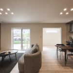 南向きの大きな窓から光がたっぷりと差し込む、明るく心地よいLDK。シンプルモダンを基調に、温かみのある木目フロアと落ち着いたトーンのアクセントクロスが空間に上品さを添えます。