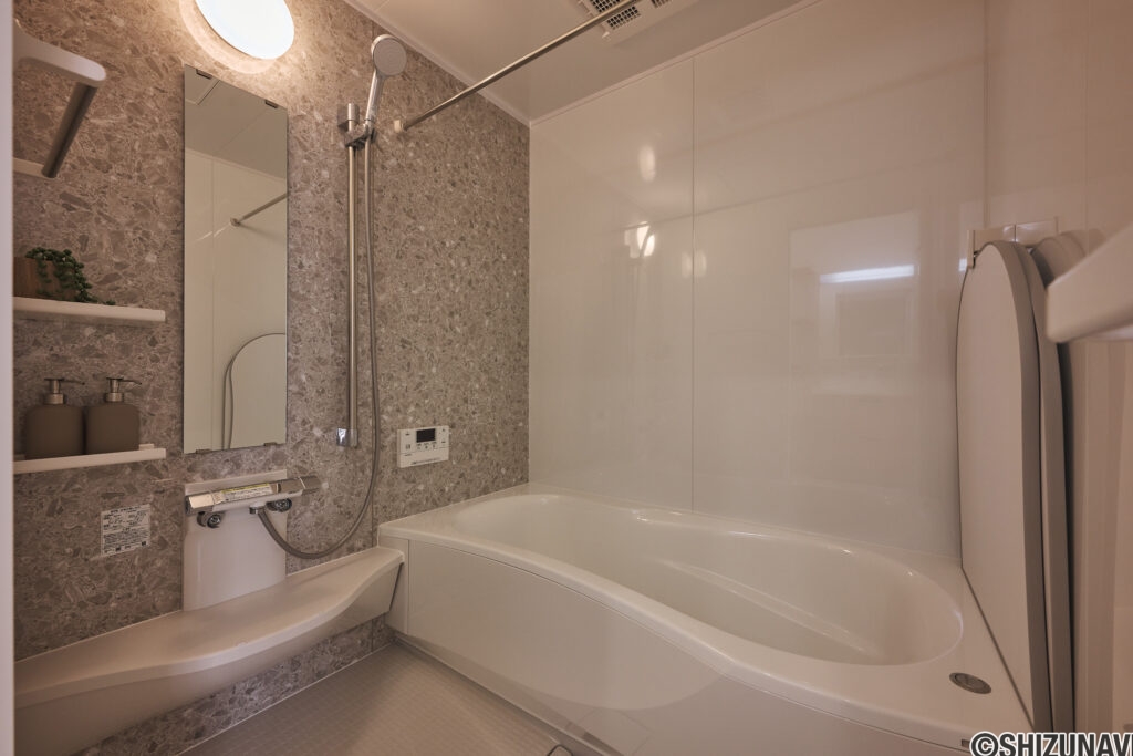 【B棟】石目調パネルが上品なバスルーム。ゆったり浴槽で手足を伸ばしてくつろげ、1日の疲れをやさしくリセット。お手入れもしやすく、いつでも清潔に保てます。