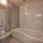 【B棟】石目調パネルが上品なバスルーム。ゆったり浴槽で手足を伸ばしてくつろげ、1日の疲れをやさしくリセット。お手入れもしやすく、いつでも清潔に保てます。