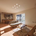 【B棟】木の温もりを効かせたナチュラルモダンのLDK。グレー×ベージュのやさしいトーンが空間に溶け込み、家具や小物が映える心地よい背景になります。