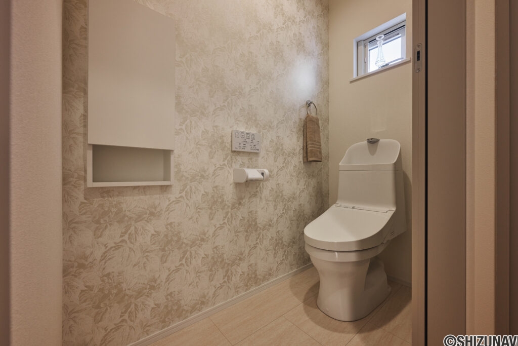 【B棟】お手洗いにもデザインクロスを合わせて、手抜きのないコーディネートに。やわらかな柄が空間に上品さを添え、毎日使う場所だからこそ心地よく整えました。