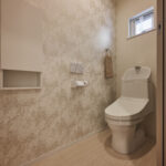 【B棟】お手洗いにもデザインクロスを合わせて、手抜きのないコーディネートに。やわらかな柄が空間に上品さを添え、毎日使う場所だからこそ心地よく整えました。