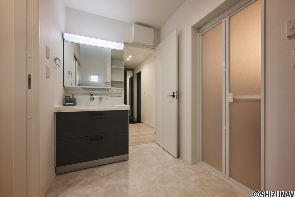 【A棟】玄関から洗面、キッチンへスムーズにつながる回遊動線。帰宅後すぐに手洗いできて、買い物袋も最短でキッチンへ。家族みんなが使いやすい、暮らしラクな間取りです。