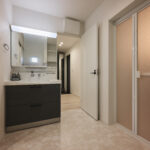 【A棟】玄関から洗面、キッチンへスムーズにつながる回遊動線。帰宅後すぐに手洗いできて、買い物袋も最短でキッチンへ。家族みんなが使いやすい、暮らしラクな間取りです。