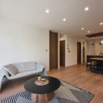 【E棟】民族柄のラグやブラックのアクセントを効かせたインテリアが、くつろぎの中にアート性と個性をプラスしています。