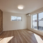 【F棟】大きな窓から光が差し込む、明るく心地よい居室。アクセントクロスが空間にさりげない個性を添え、寝室や子ども部屋、ワークスペースなど多彩に活躍します。