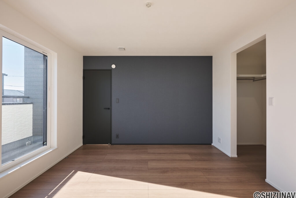 【A棟】落ち着いたアクセントクロスが心地よい主寝室。大きな窓から朝日が差し込み、気持ちよく目覚められます。ウォークインクローゼット付きで、寝室もすっきり整います。