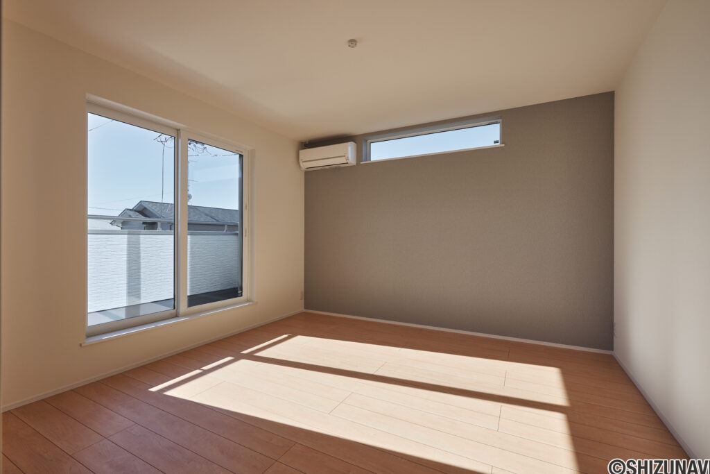 【B棟】大きな窓から光が差し込む、明るく心地よい主寝室。落ち着いたアクセントクロスが空間を引き締め、1日の終わりをゆったり過ごせるくつろぎの場所です。