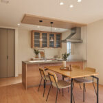 【B棟】木目のキッチンと天井が、空間にほっとする温もりをプラス。やわらかな質感に包まれて、家族の会話も自然と弾む、安心感のあるダイニングです。