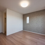 【E棟】シックな色合いのアクセントクロスが空間にほどよい個性をプラスし、心を落ち着かせてくれる寝室に。