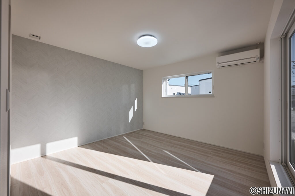 【A棟】 アクセントクロスが上品な印象を与える主寝室。やわらかな自然光が差し込み、1日の疲れを癒す落ち着いた空間です。