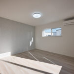 【A棟】 アクセントクロスが上品な印象を与える主寝室。やわらかな自然光が差し込み、1日の疲れを癒す落ち着いた空間です。