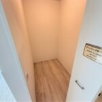 １号棟　ファミリークロークリビング手前のファミリークローク。1帖ほどの広さがあり、棚を置いたり使い方も自由にカスタム可能。