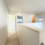 ２号棟　２階廊下吹き抜けにある階段を上ると２階に。明るさと開放感があります。