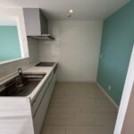 キッチンの別角度のお写真です。スペースが広く、後ろの水色の壁紙がアクセントになっております。