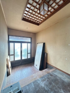 【玄関内観】フローリング上張り、壁紙張替え、照明器具交換、玄関扉の新品交換を行います。