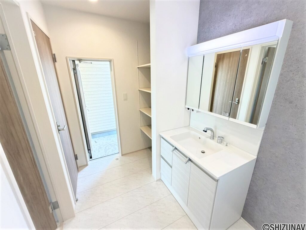 ３号棟　洗面三面鏡タイプなので、鏡の後ろにも収納あります。可動式の収納もご家庭の使い方に合わせて変更可能。勝手口からは北川のインナーバルコニーにアクセスできます♪