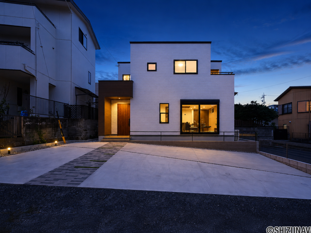 夕景に映える、白を基調としたシンプルモダンな外観。室内からこぼれる温かな灯りが、上質な住まいを演出します。