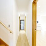 【リフォーム後／1階廊下】廊下はフローリングの重ね張り、クロス貼替、照明交換を行いました。