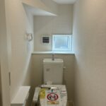 １階トイレです。左手前に壁埋め込み収納がございます。