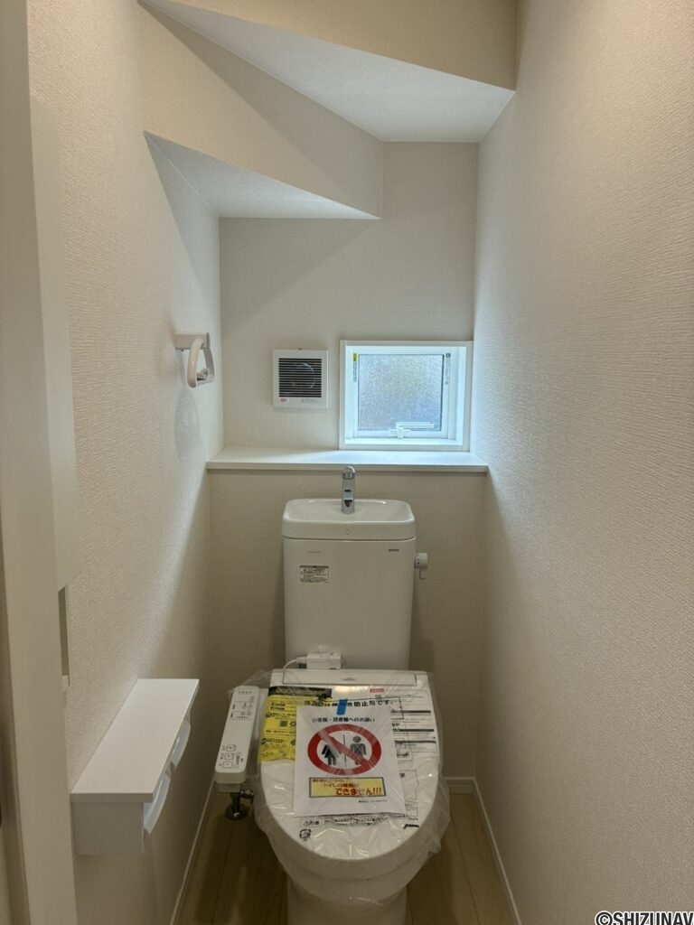 １階トイレです。左手前に壁埋め込み収納がございます。