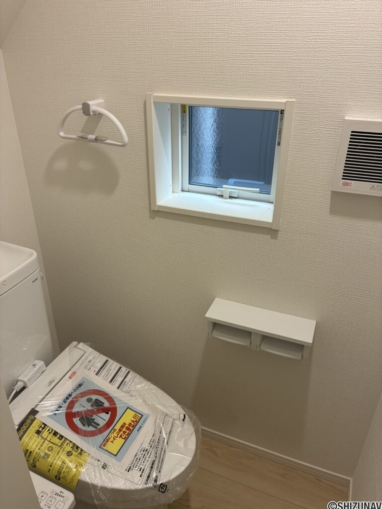 １階トイレです。左手前に壁埋め込み収納がございます。