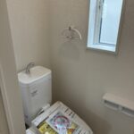 ２階トイレです。右側に壁埋め込み収納がございます。