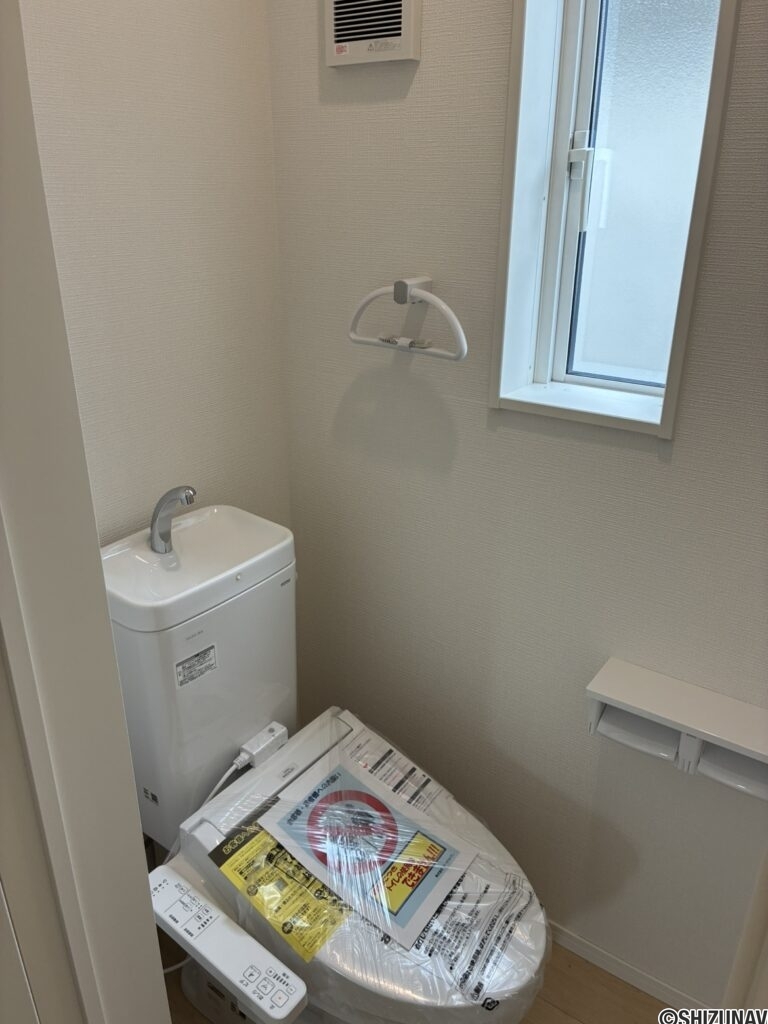２階トイレです。右側に壁埋め込み収納がございます。