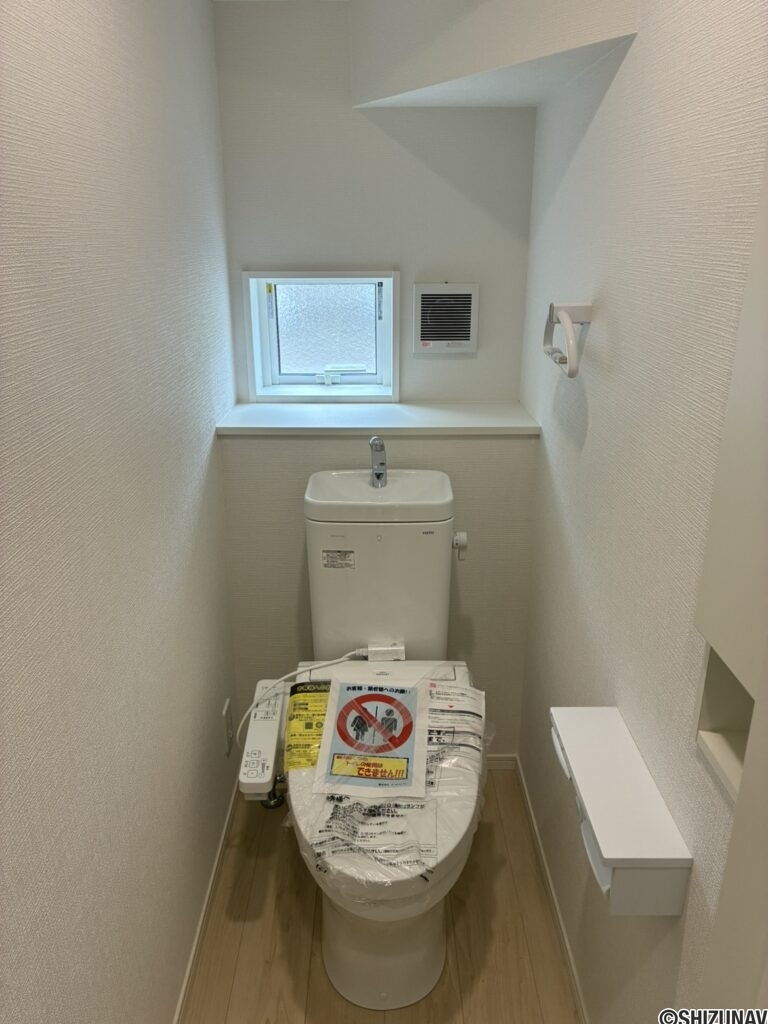 １階トイレです。右手前に壁埋め込み収納がございます。