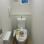 １階トイレです。左手前に壁埋め込み収納がございます。