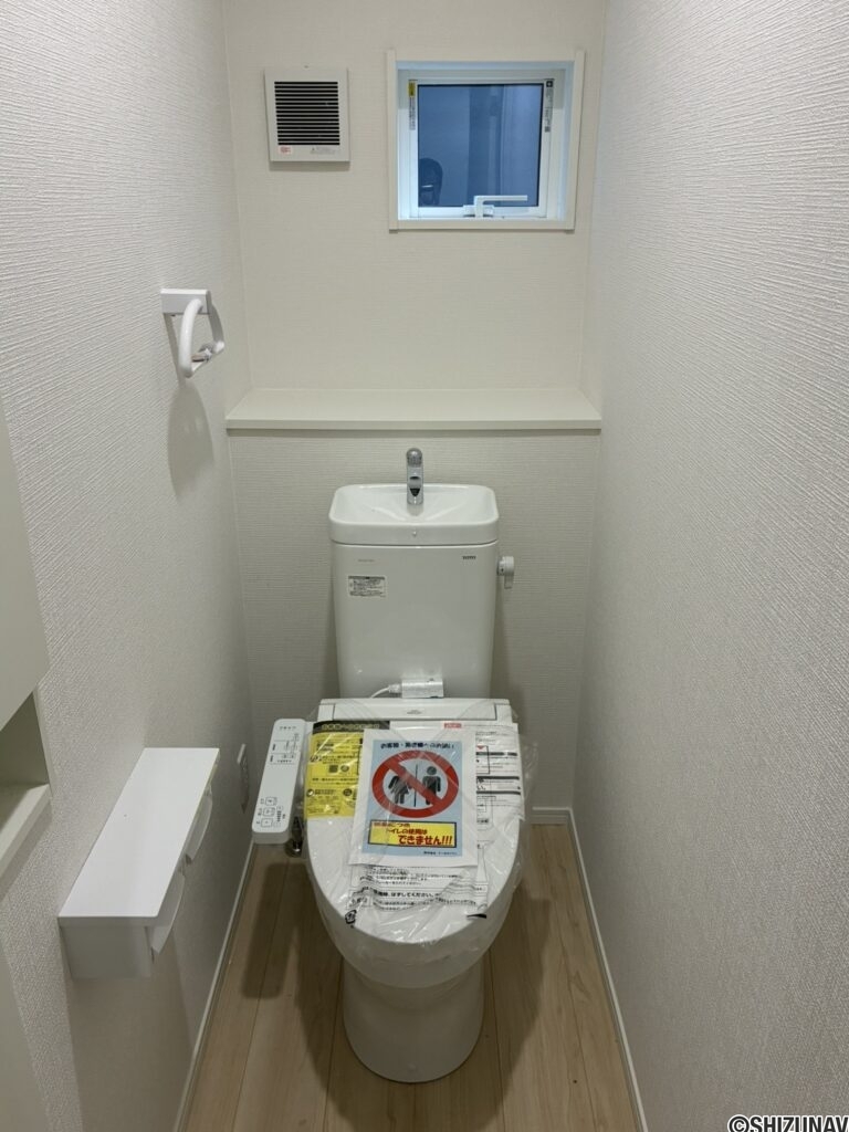 １階トイレです。左手前に壁埋め込み収納がございます。