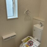 ２階トイレです。左側に壁埋め込み収納がございます。