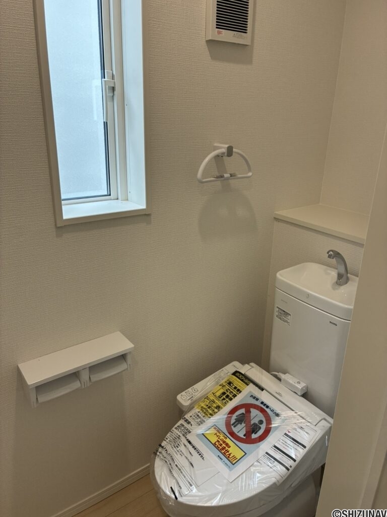 ２階トイレです。左側に壁埋め込み収納がございます。